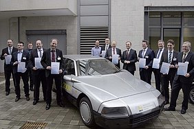 Die Repräsentanten der Projektpartner mit ihren Förder-Urkunden vor dem Projektfahrzeug des UNI-CAR-Projektes von 1982