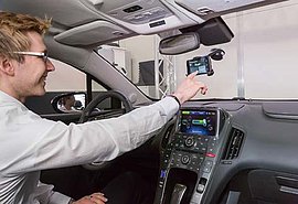 Junger Mann hinter dem Steuer bedient einen Touchscreen